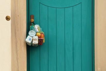 delivery during the quarantine. Shopping bag with Merchandise, goods and food is hanging at the...