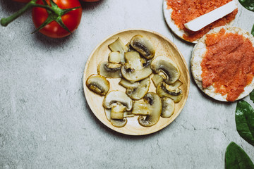 Fresh mushrooms with tomatoes on grey background. Vegan healthy food concept