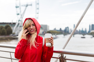 girl drinking coffee and talking on the phone in centre of london