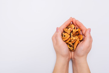 Female hands with sliced dried garden apples. Dried fruits. Healthy, natural foods. White background Close-up.