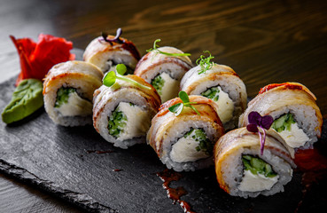 sushi roll with cream cheese and eel in plate on wooden table background