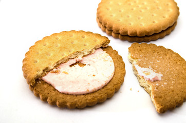 sandwich cookies on a white background. broken tasty cracker with pink cream.