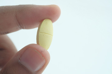 Close-up shot of pill in hand isolated on white 