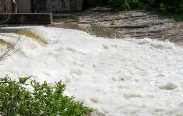 Flood waters are a foaming blur as the wild raging waters race down river taking with it anything...