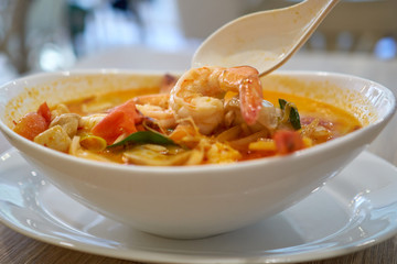 Hot Tom Yum Kun soup with shrimps in thai restaurant in Bangkok, Thailand.