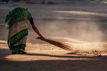 old Indian lady sweeping streets