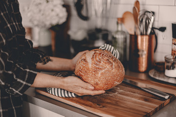 Homemade sourdough bread. Bright white kitchen. Bread on cutting board. Kitchen utensils. Craft...