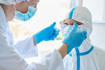 Medical professionals in clinics prepare in protective clothing