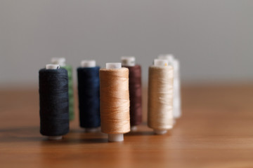 close-up of colored sewing threads on a wooden background with a place for the inscription. the view from the top
