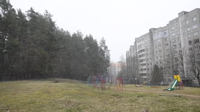 snow falls against the background of an empty Playground, an unexpected snowfall.