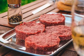 Raw Hamburger Patties on the Garden Table