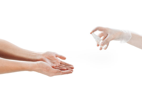 Disinfection of the hands. The palms are disinfected from a can. A hand in a transparent latex glove holds an antiseptic. Photo on a white background.