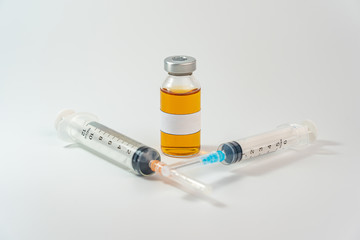Orange vaccine bottle with blank label and syringe injection on white background