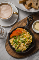 Breakfast table with scrambled eggs with coffee