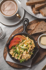 Breakfast table with scrambled eggs with coffee