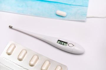 Electronic medical thermometer showing the temperature of 36.6 C lies on a white background