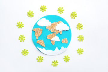 paper application: planet Earth, continents, clouds, sun and green viruses around on a white background. Coronavirus pandemic concept.