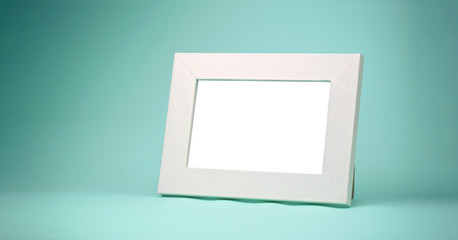 blank wooden photo frame standing on blue table at home