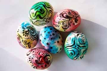 Colorful Easter eggs with a graphic pattern lie on a white background. Easter concert.