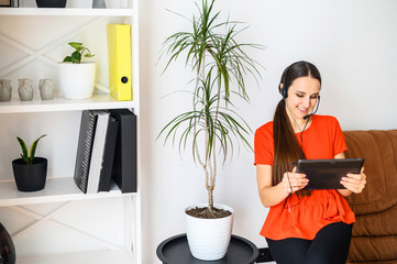 Young woman with hands free headset and tablet