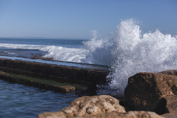 Fototapeta na wymiar Explosão de água do mar batendo nas rochas