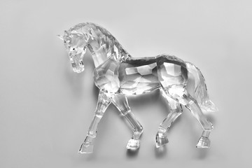 Crystal horse on a grey background.