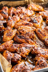 Grilled chicken wings in barbecue sauce in baking tray.