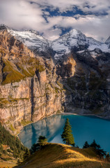 Naklejka premium Scenic top view of Oeschinensee, Oeschinen Lake by Kandersteg, Switzerland. High mountains and rocks in background. Swiss Alps.