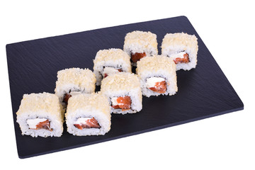 Traditional fresh japanese sushi rolls on a black stone Caesar with Salmon Roll on a white background. Roll ingredients: salmon, philadelphia, tomato, nori, rice, panko crackers.