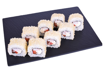Traditional fresh japanese sushi rolls on a black stone Caesar Ebi Roll on a white background. Roll ingredients: shrimp, philadelphia, tomato, nori, rice, panko crackers.