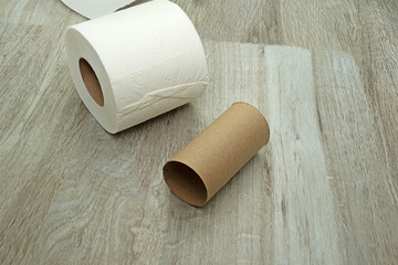 toilet paper on the floor made of ceramic tiles. New and used rolls of white toilet paper.