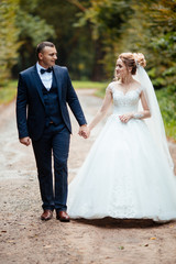 Bride and groom in a park kissing.couple newlyweds bride and groom at a wedding in nature green forest are kissing photo portrait.Wedding Couple