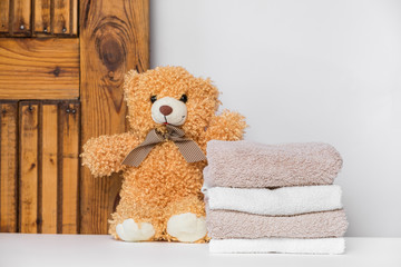 Teddy bear and a stack of clean and fresh cotton towels