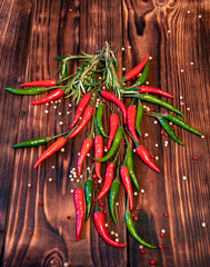 Red and green hot peppers on a wooden table top.