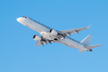Modern white passenger airplane flies in the air on a clear sunny day against a clear blue sky