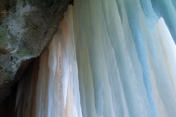 Blue and brown icicles dangle from the ceiling of an ice cave at Pictured Rocks National Lakeshore, Michigan's Upper Peninsula, USA