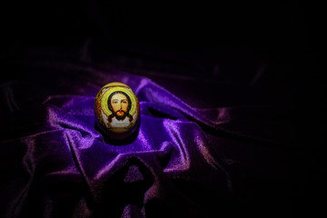 Easter egg with the face of Jesus Christ on velvet. Background for an Easter card.