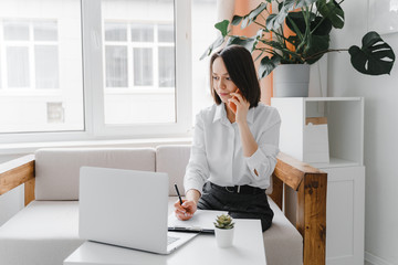 Young businesswoman talking on the phone at home or office.