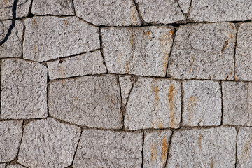 Texture of stone wall made of grey stones