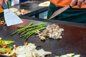 Cheff preparing traditional Mediterranean squid dish on a hot grill.