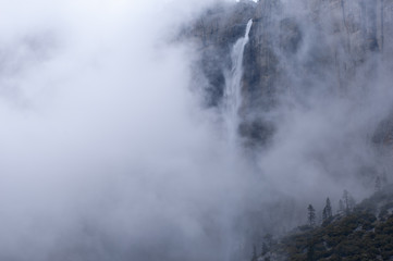 Fototapeta na wymiar Winter landscape of Upper Yosemite Falls in fog captured with motion blur, Yosemite National Park, California, USA