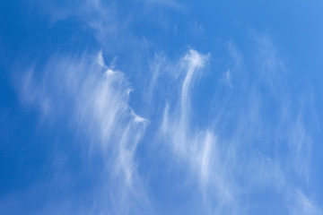 Big bright unusual beautiful sky with white creative clouds. Blue sky with unusual cumulus fluffy clouds as a natural background for design