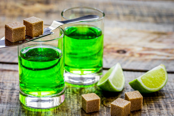 green shots with sugar and lime on table background