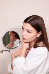 Girl in the bathroom. Reflection in the mirror. Copy of the space.