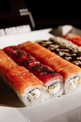 Sushi, Asian food, rolls, Philadelphia, sesame. Restaurant food. Fast food. Sushi set, set lunch. On a black background.