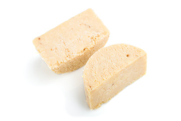 Piece of cheddar cheese isolated on white background. Side view.