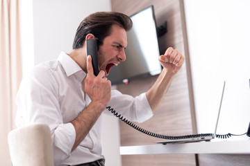 Handsome businessman talking on the phone in room and feeling so excited and happy