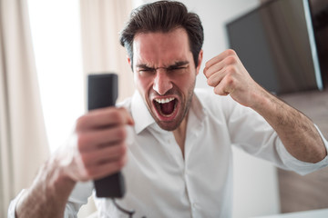 Single businessman feeling so angry and crazy, he looking in the phone with hand up