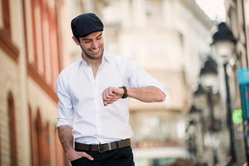 Single stylish male with sicilian cap smiling and looking, what is time