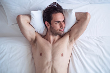 Fototapeta na wymiar Handsome male in bed chilling and having nice moments in the morning
